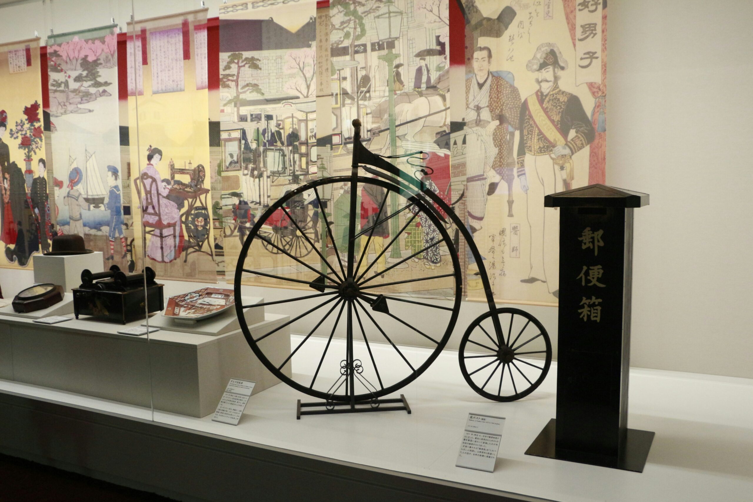 Vintage penny-farthing bicycle and historical japanese artifacts on display.